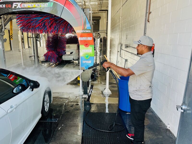 Marvel Car Wash team member pre-washing vehicle