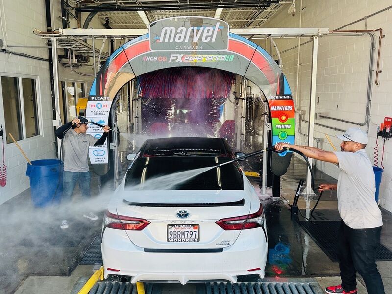 Team washing car in Marvel express tunnel