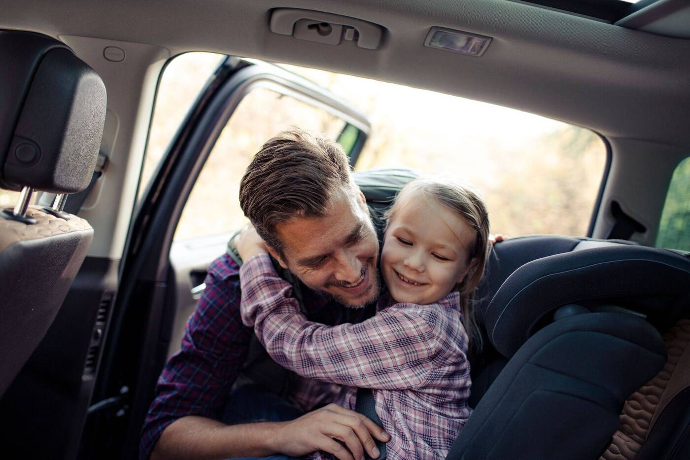Happy dad and daughter in a clean car